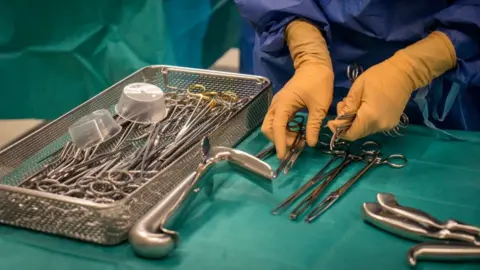 Getty Images Medic with gloves and instruments