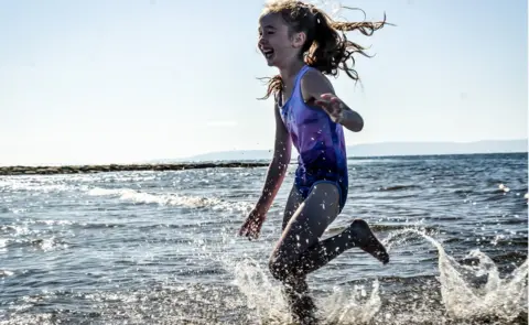 Getty Images Girl splashing in seawater