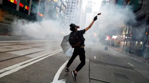 Reuters An anti-government protester reacts as police fire tear gas during a march billed as a global "emergency call" for autonomy, in Hong Kong, China, on 2 November 2019