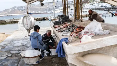Getty Images A fisherman cleans fish on May 26, 2020 in Mykonos, Greece