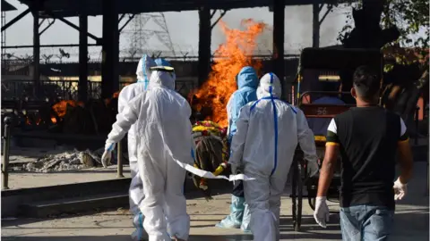 Getty Images The body of a person who died of Covid-19 is taken for cremation