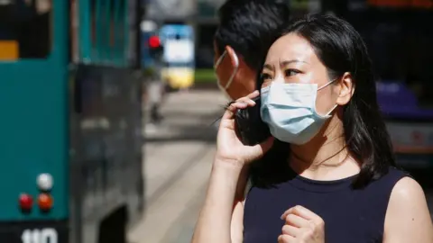 Reuters A woman wears a surgical mask in Hong Kong