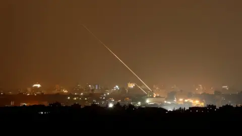 Reuters Rockets are launched from the northern Gaza Strip towards Israel, as seen from Sderot, Israel