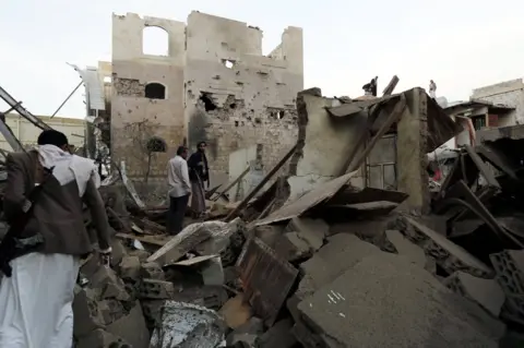 EPA Yemenis inspect destroyed houses after an alleged Saudi-led coalition air strike targeted a district in Sanaa, Yemen (9 June 2017)