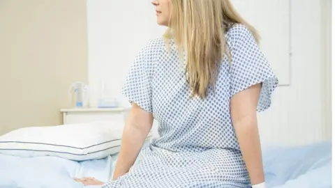 Getty Images Woman in doctor's office for check up. - stock photo