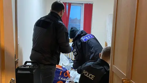 Officers seizing evidence during one of the raids