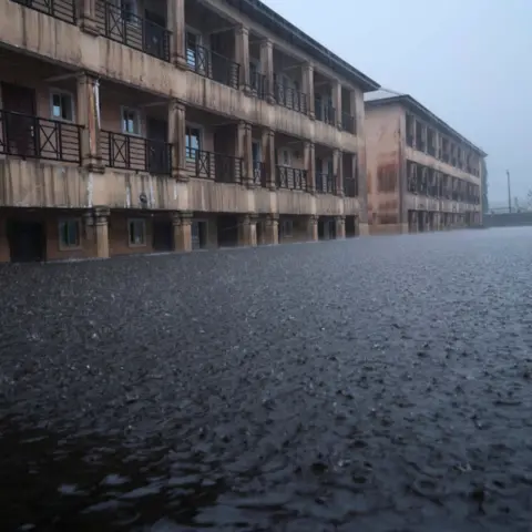 Gideon Mendel Rain and flood waters outside Dorca Executive Apartments (student accommodation) in Ogbia Municipality, Bayelsa State, Nigeria - November 2022