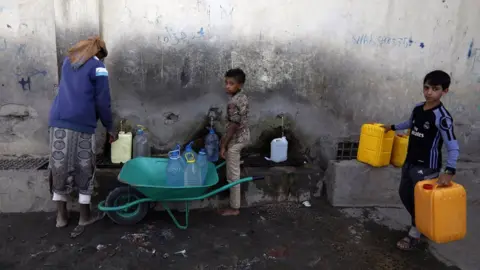 EPA People collect water at a communal tap in Sanaa, Yemen (1 June 2020)