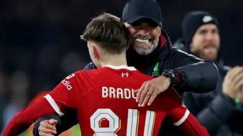 Action Images/Reuters Liverpool manager Jurgen Klopp embraces Conor Bradley after the Carabao Cup semi final second leg match