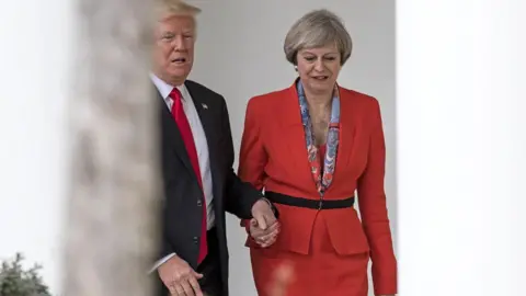 Getty Images Former British Prime Minister Theresa May and Former President Donald Trump walk along The Colonnade of the West Wing at The White House on January 27, 2017