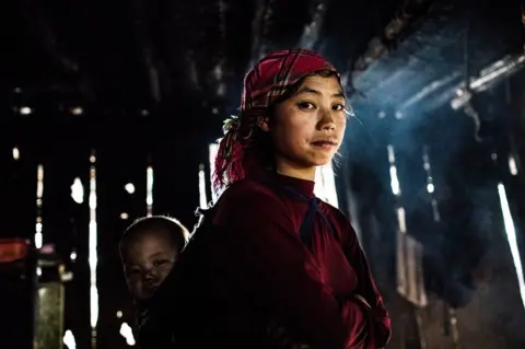 Plan International / Vincent Tremeau Mi's sister-in-law with her child