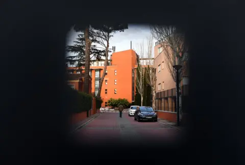 Getty Images A person walks behind the door of the Monte Hermoso residence for the elderly in Madrid on 17 March, 2020