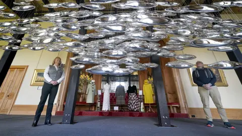 PA Media Artist Joseph Rossano and assistant curator Sarah Hoare view The Salmon School art installation on display in the Castle Ballroom at the opening of Life at Balmoral, the Platinum Jubilee exhibition at Balmoral Castle, in Royal Deeside, Aberdeenshire