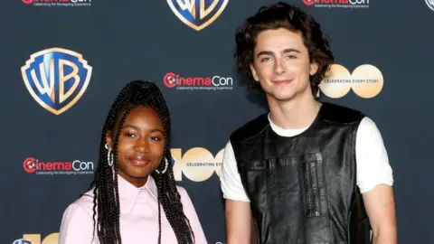 Reuters Calah Lane (L) and Timothee Chalamet, promoting the movie Wonka, attend a Warner Bros presentation during CinemaCon, the official convention of the National Association of Theatre Owners, in Las Vegas, Nevada