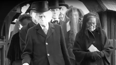 Actors portray the funeral scene