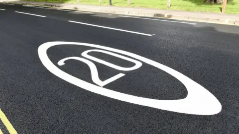 Peter Dazeley/Getty 20 mph sign painted on road