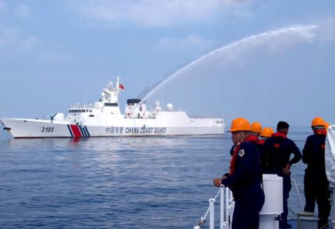 A Chinese vessesl sprays water at a Philippines coastguard ship
