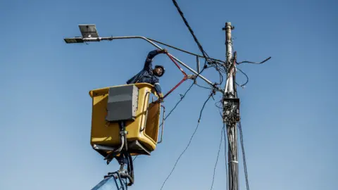 AFP A worker cutting electricity cables in Johannesburg, South Africa - Thursday 9 June 2022