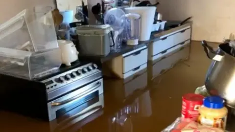 B D Roberts Flood water surrounding oven in a kitchen