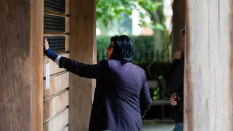 PA Media Family members attending a private memorial service, lay flowers in the September 11 Memorial Garden in Grosvenor Square, London