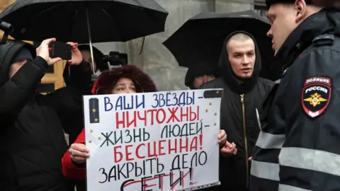 Getty Images Protester holding a sign supporting the Set defendants outside FSB