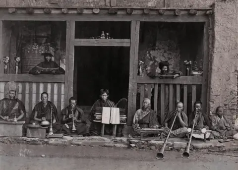 Robert Philips / Hulton Archive / Getty Images A row of buddhist Musicians, Darjeeling