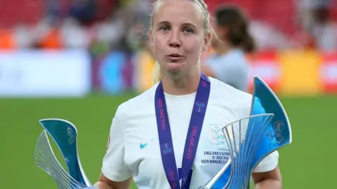 Beth Mead holding two trophies