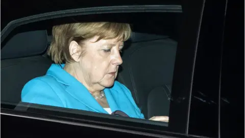 Getty Images German Chancellor Angela Merkel leaves after a party leadership meeting at the CDU headquarters in Berlin, on July 2, 2018