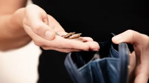 SEAN GLADWELL Woman counts money from purse