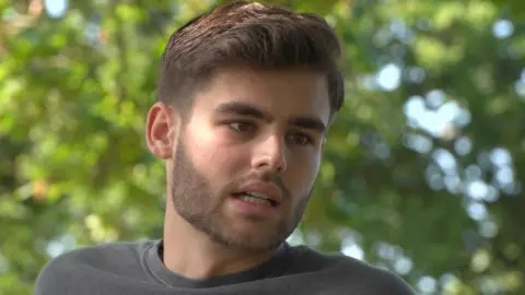 BBC Face of Jake standing in front of trees