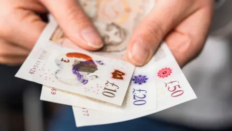 Getty Images Person holds polymer bank notes