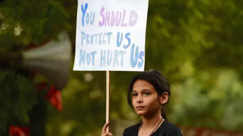 Getty Images An Indian demonstrator holds a placard during a silent protest 'Not In My Name' in support of rape victims.