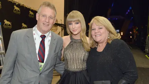 Getty Images Taylor Swift with her parents in 2013