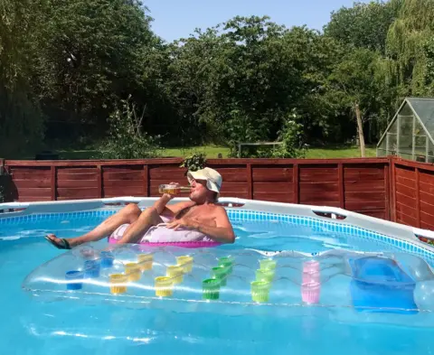 Helen Clarke man drinking beer in his garden in Hadleigh in Suffolk