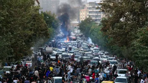 Getty Images Protesters block a street in Tehran