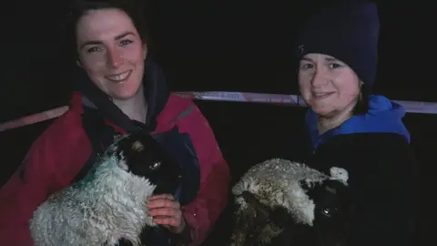 NIFRS Two women hold the rescued lambs