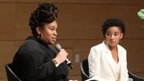 Getty Images Angie Thomas and Amandla Stenberg speak onstage during Teen Vogue Summit 2018