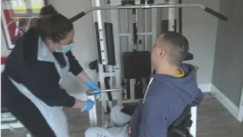 Steve using gym equipment with help from carer Jazzmine Mace