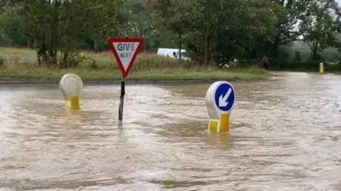 LEX/BBC WEATHERWATCHERS High flood waters around street signs