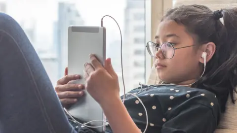 Getty Images A girl and an ipad