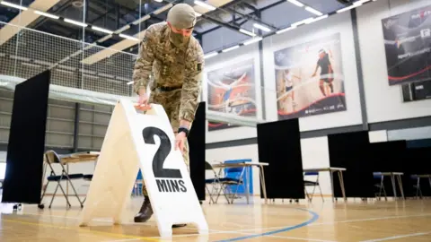 PA Media Members of the Royal Scots Dragoon Guard help set up a vaccination centre at the Ravenscraig Regional Sports Facility