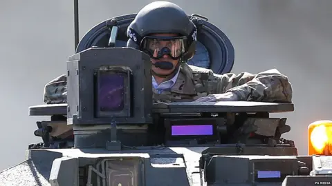 PA Media Gavin Williamson takes a ride in a Challenger 2 tank