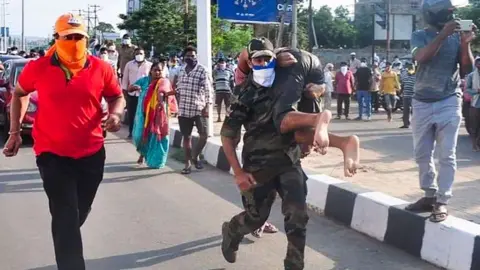 Getty Images Rescuers evacuate people following a gas leak incident at an LG Polymers plant in Visakhapatnam on May 7, 2020