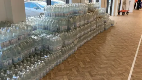 Jozef Hall/BBC Water bottles in a community centre