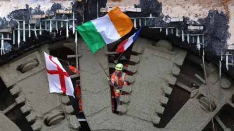 Neil Hall HS2 workers wave flags on the cutter head of the tunnel-boring machine Cecilia breaking through on the Chiltern Tunnel