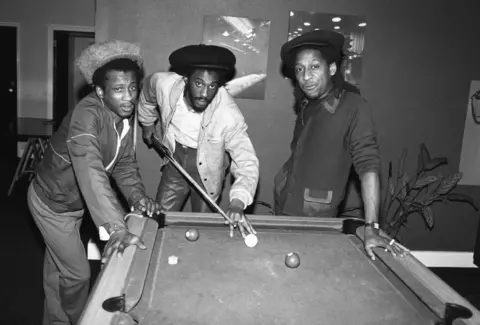 Getty Images A black and white shot of the reggae band Aswad playing pool in 1982