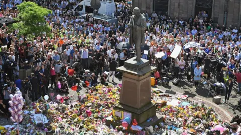 Getty Images People gather for minute's silence at St Ann's square