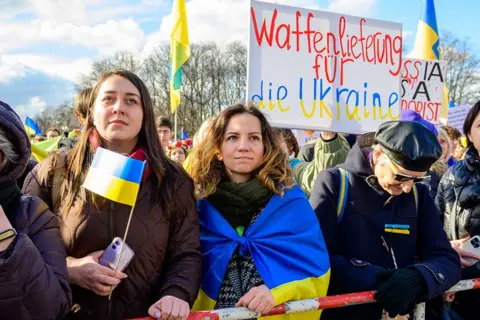 AFP women hold Ukrain flags at a protest