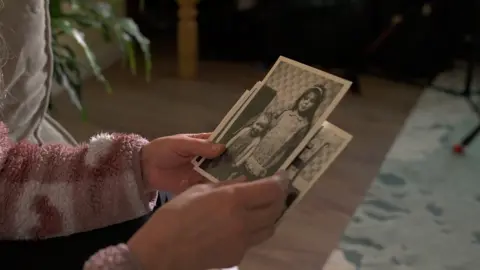 women looking at a picture of two young girls 