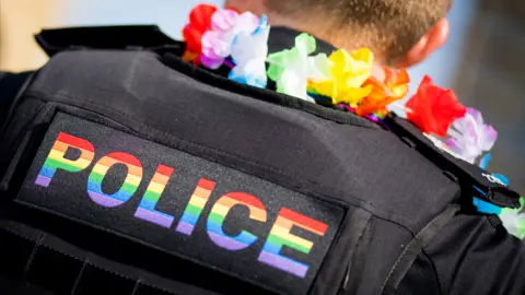 Getty Images Policeman with 'Police' written on his back in the colours of the LGBTQ flag